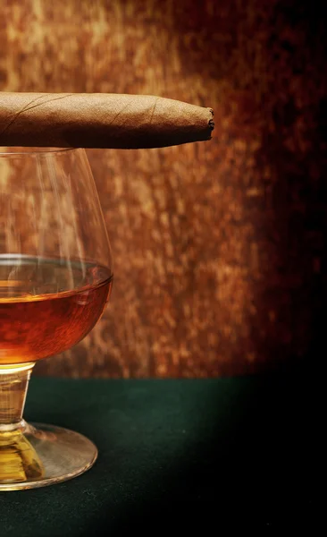 Cigar on the glass with alcohol on green fabric — Stock Photo, Image