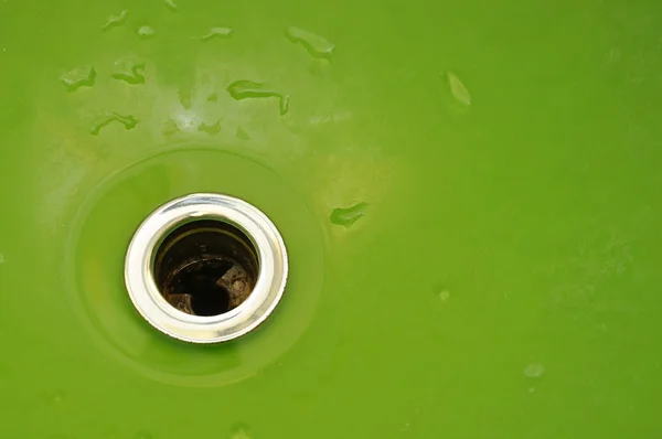 Druppels van zuiver water in een groene gootsteen — Stockfoto