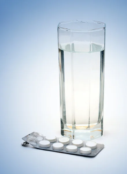 Medicina, tira e vidro de água — Fotografia de Stock