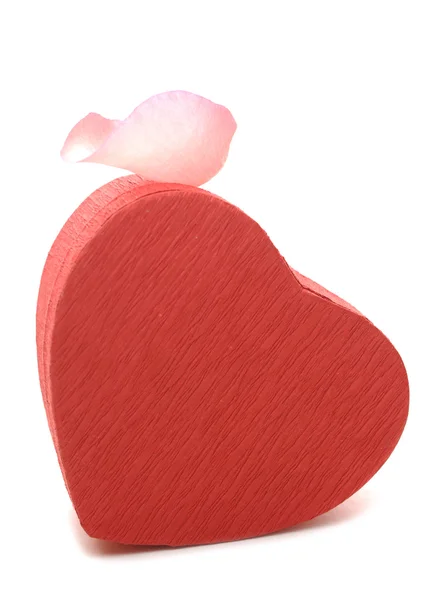 Caixa de presente em forma de coração vermelho com pétala de rosa — Fotografia de Stock