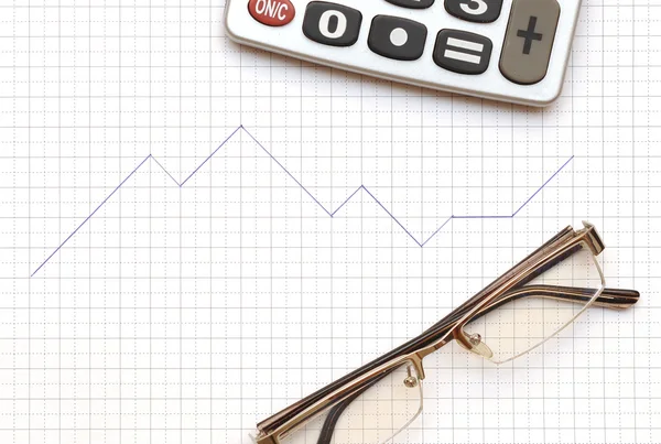 Brille, Taschenrechner und Arbeitspapier mit Diagramm — Stockfoto