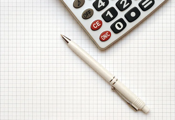 Ручка и калькулятор на рабочей бумаге — стоковое фото