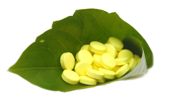 Yellow pill in green leaf — Stock Photo, Image
