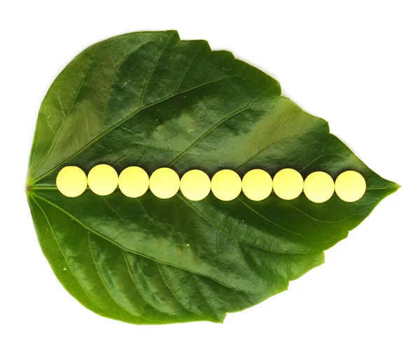Κίτρινο χάπι πάνω από ένα πράσινο φύλλο — Φωτογραφία Αρχείου