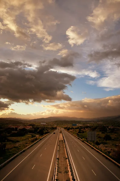 Molnigt solnedgång över motorvägen — Stockfoto