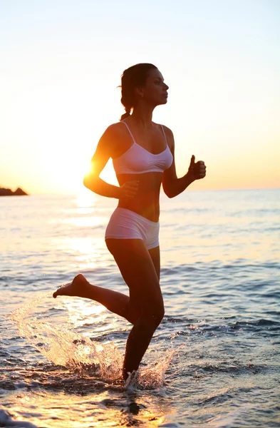 Sexy brunette is running on the beach — Stock Photo, Image