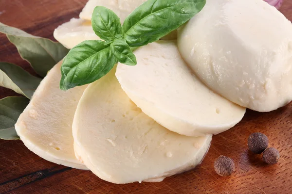Mozzarella cheese and basil on a wooden board — Stock Photo, Image