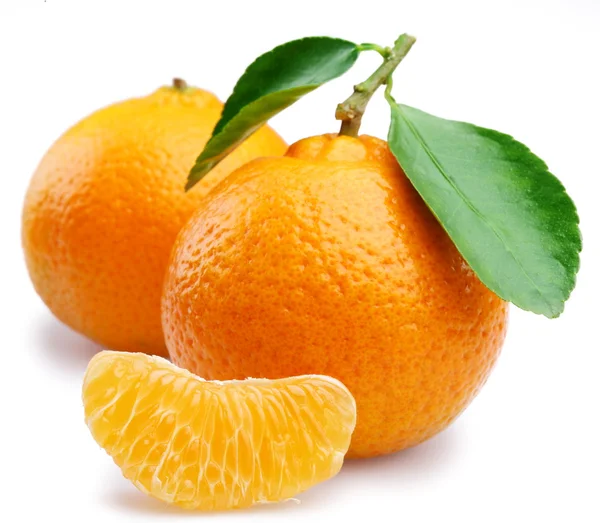 Ripe tangerines with leaves and slices on white background — Stock Photo, Image