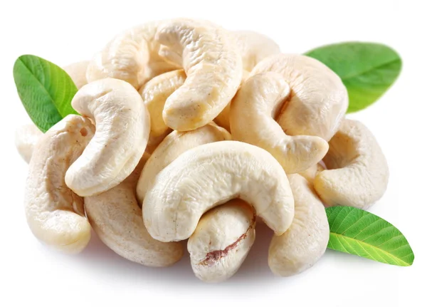 stock image Ripe cashew nuts with leaves on a white background.