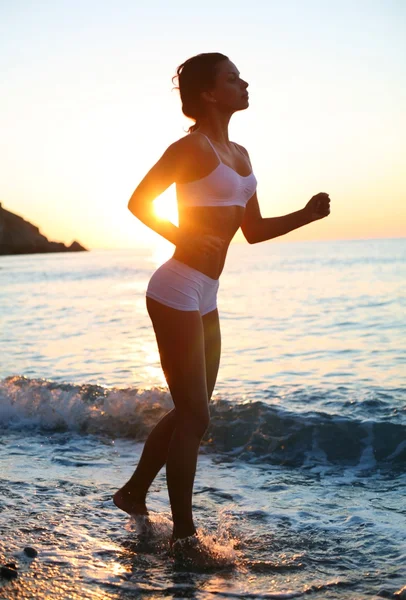Morena sexy está correndo na praia — Fotografia de Stock