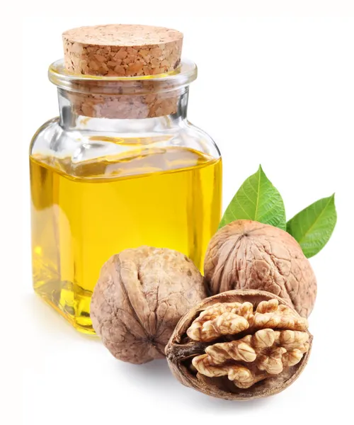 Walnut oil and nuts on white background. — Stock Photo, Image