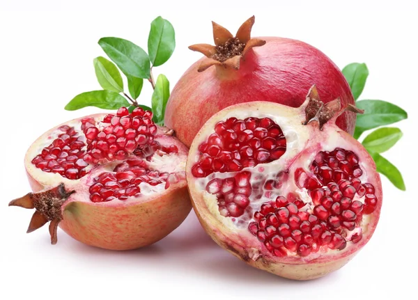 Juicy opened pomegranate with leaves. — Stock Photo, Image