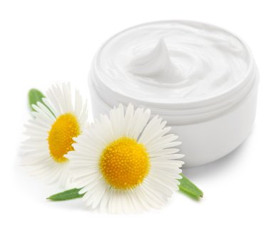 Opened plastic container with cream and camomile. clipart
