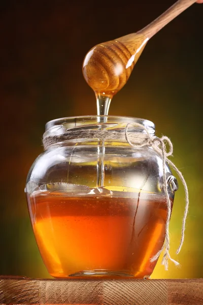 Dolce miele versato dal drizzler nella pentola . — Foto Stock
