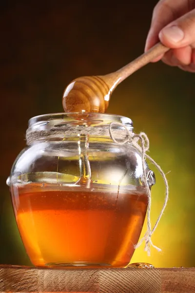 Sweet honey pouring from drizzler into the pot. — Stock Photo, Image