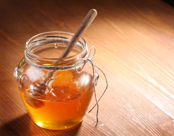 Pot of honey and wooden in it. — Stock Photo, Image