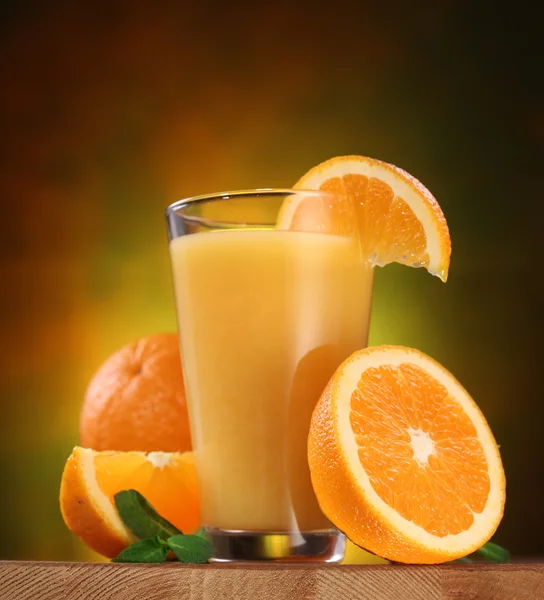 Pomeranče a sklenici šťávy. — Stock fotografie