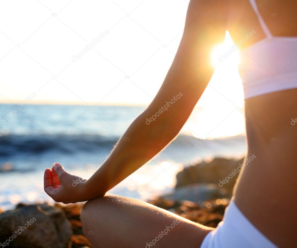 Body of a beautiful girl in a meditation on the beach