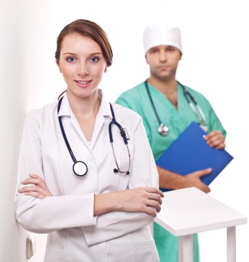 Portrait of doctor with her colleague in the background. clipart