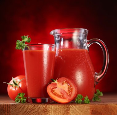 Jug and glass full of tomato juice. clipart