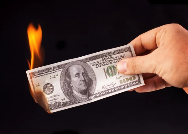 Dólar ardente na mão isolado em um preto — Fotografia de Stock