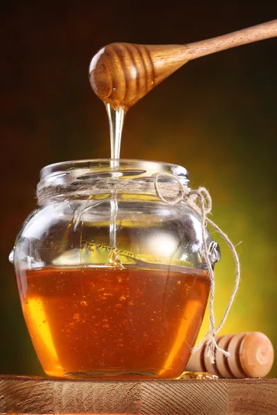 Dulce miel que vierte del rociador en la olla — Foto de Stock