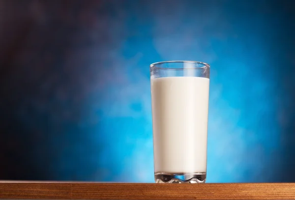 Γεμάτο ποτήρι γάλα στο ξύλινο τραπέζι. — Φωτογραφία Αρχείου