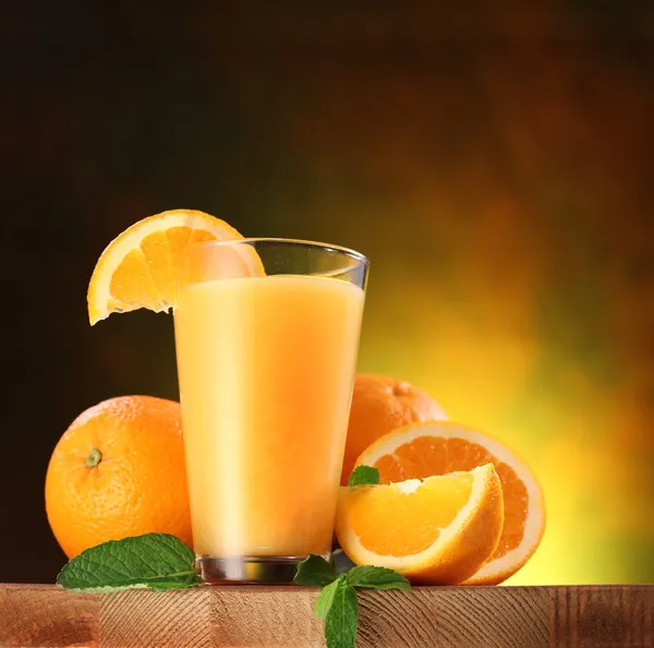 Pomarańcze i szklanką soku. — Zdjęcie stockowe
