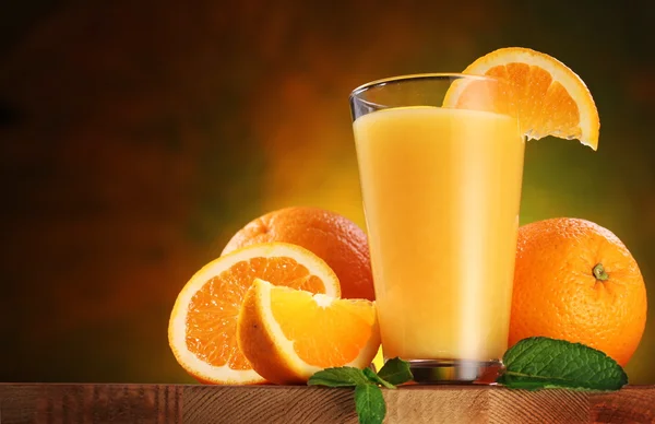 Apelsiner och glas saft. — Stockfoto