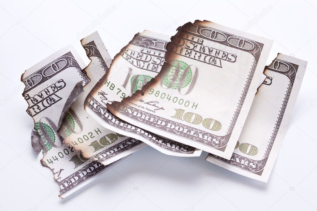 Burned dollar bills on white background