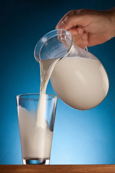 stock image Glass and jar of milk on a blue background.