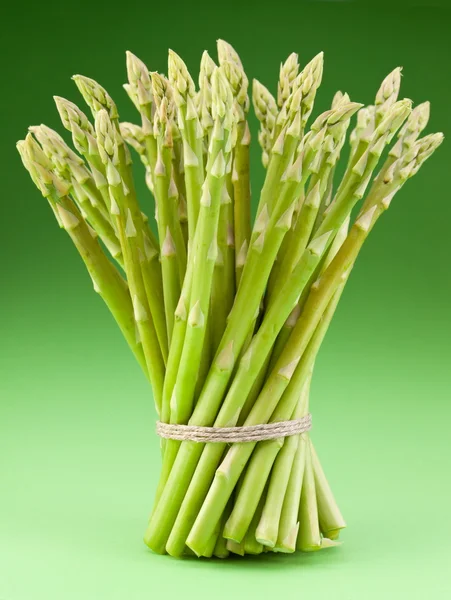 Sheaf of asparagus on a green background. — Stock Photo, Image