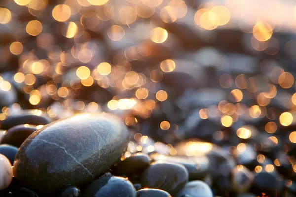 Background with sea stones and orange blurred circles. — Stock Photo, Image