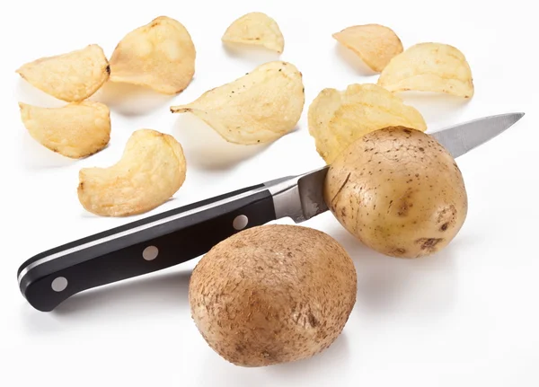 Stock image Conceptual image - the knife cuts fresh potatoes and potato chip