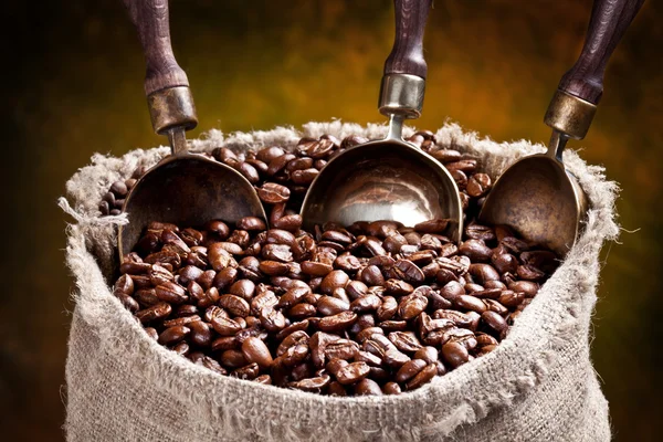 Sack Kaffeebohnen und Schaufel. auf dunklem Hintergrund. — Stockfoto