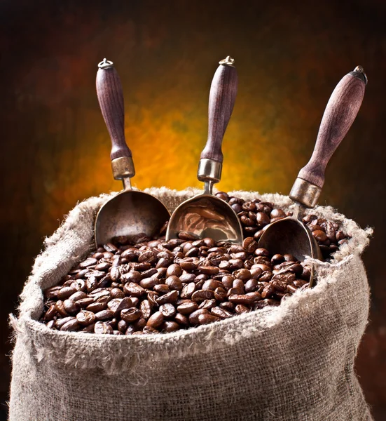 Мешок кофейных зерен и сенсация. На темном фоне . — стоковое фото