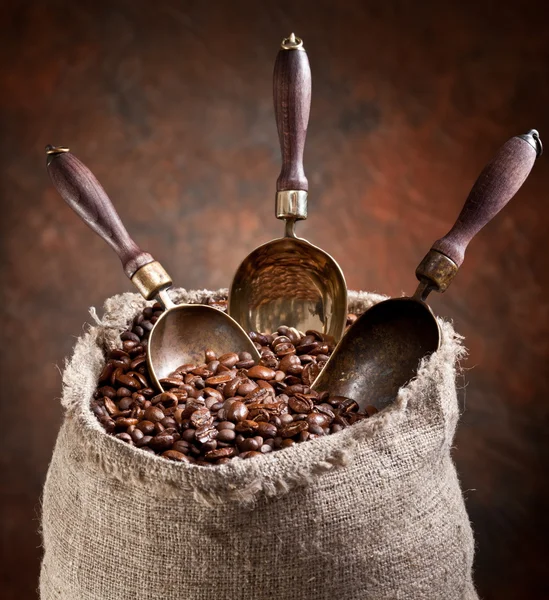 Sack Kaffeebohnen und Schaufel. auf dunklem Hintergrund. — Stockfoto