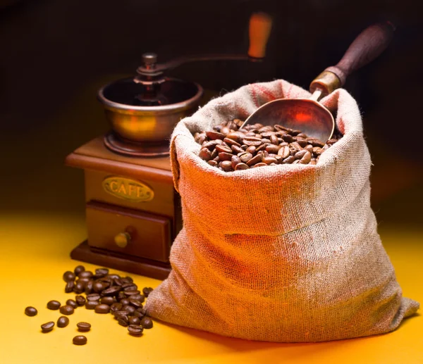 Sack of coffee beans and scoop. On a dark background.