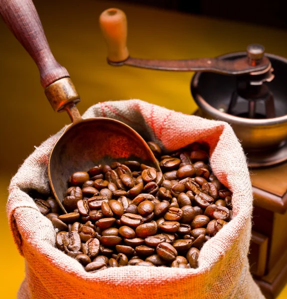 Säck kaffebönor och scoop. på en gul bakgrund. — Stockfoto