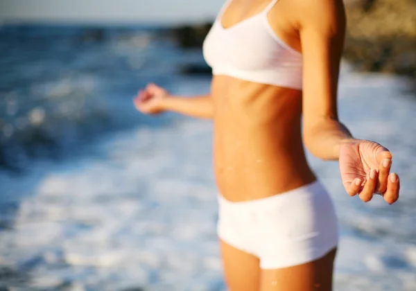 Mooie brunette doen fysieke oefeningen op het strand. — Stockfoto