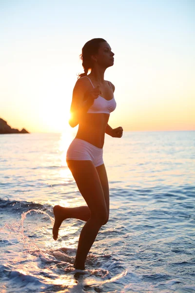 Sexy brunette is running on the beach — Stock Photo, Image