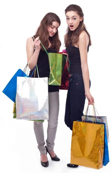 Image of two girls with their purchases. Isolated on white backg — Stock Photo, Image