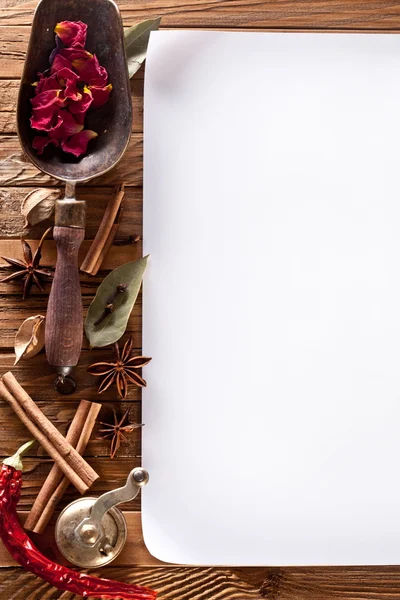 Bilden av vitt papper med kryddor på en trä yta — Stockfoto
