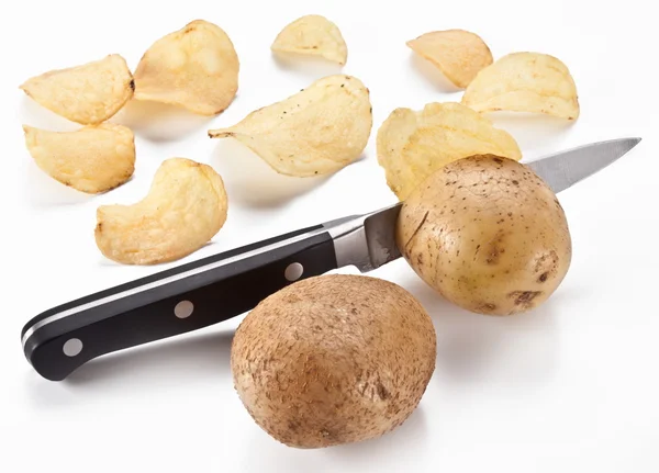 Conceptual image - the knife cuts fresh potatoes and potato chip Royalty Free Stock Images