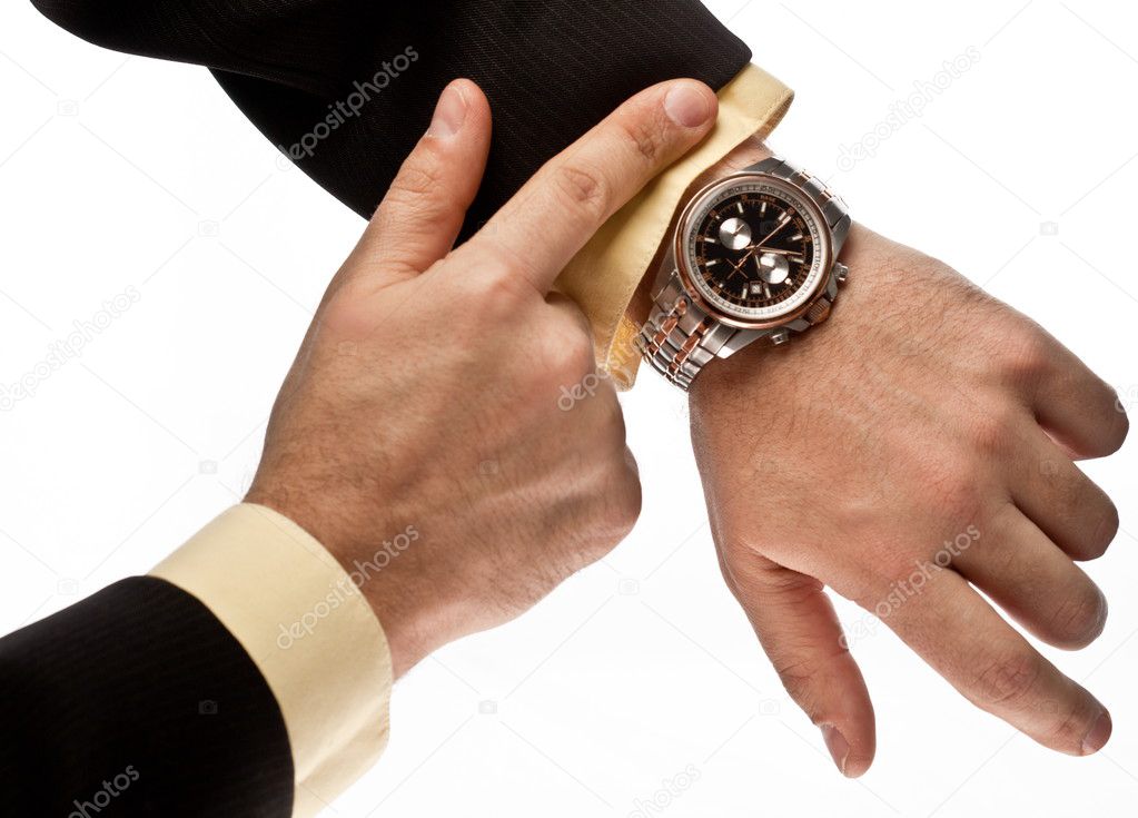 Man's hand in the suit pointing on his watch