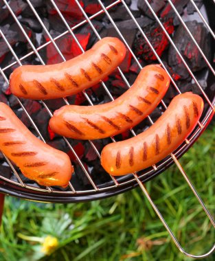 Hot sausages on barbecue clipart