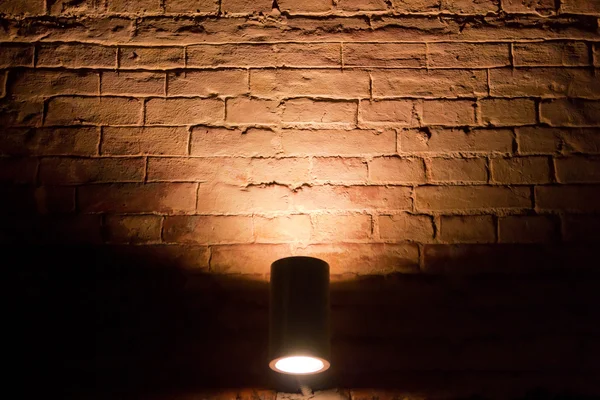 Verlicht door een bakstenen muur in het donker — Stockfoto