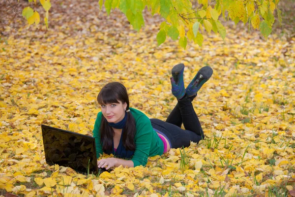 Красивая девушка с желтой осенней листвой — стоковое фото