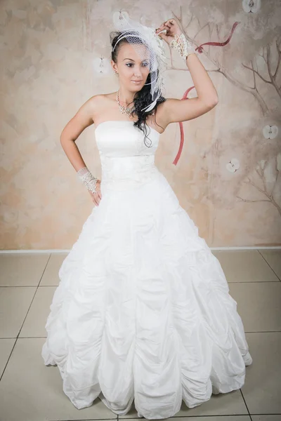 Gentle bride stands in a chic white dress