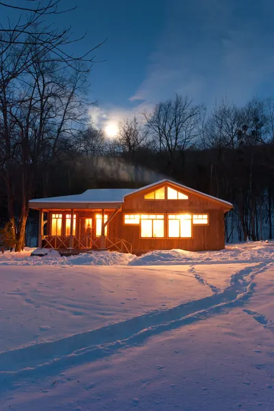 Casa de madera en un bosque nevado — Foto de Stock